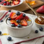 Pouring chia seed mixture into mason jars with fruit toppings nearby."